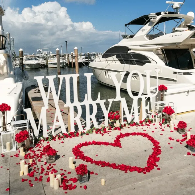 Will you marry me sign at marina with yacht in Miami