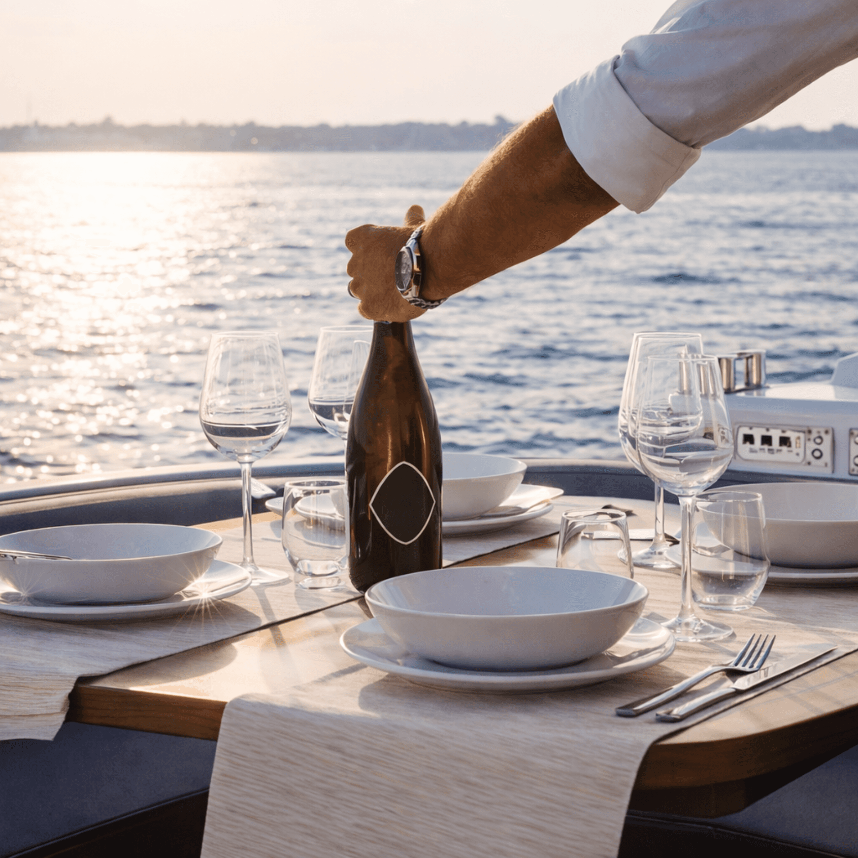 Wine service on yacht deck at golden hour