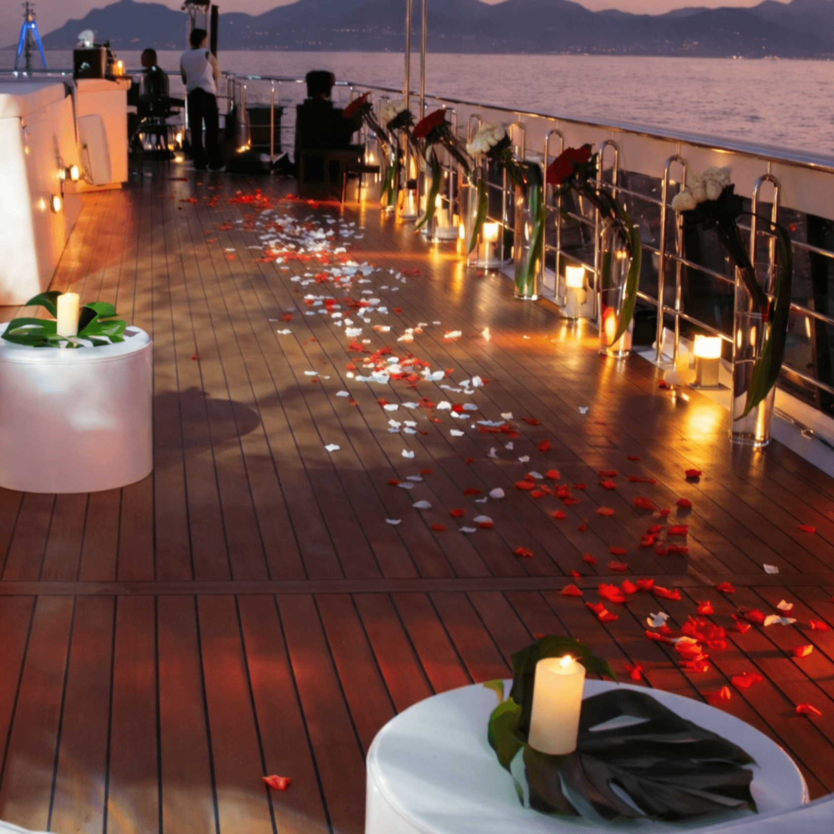 Romantic rose petal decorated yacht deck at sunset